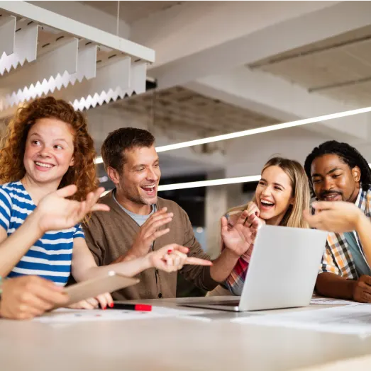 Developers discussing work around a laptop in a shared workspace