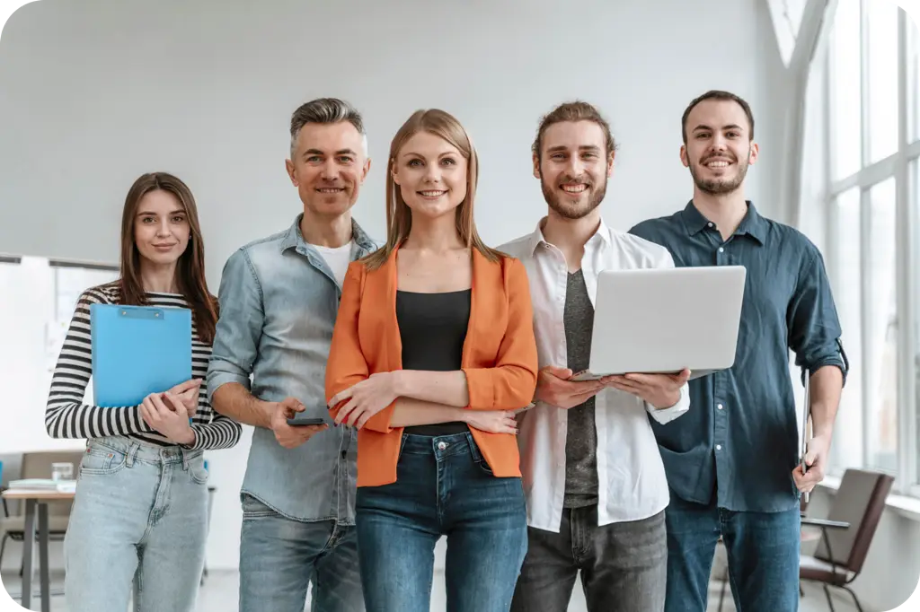 A team of software professionals with a laptop and clipboard in a bright office
